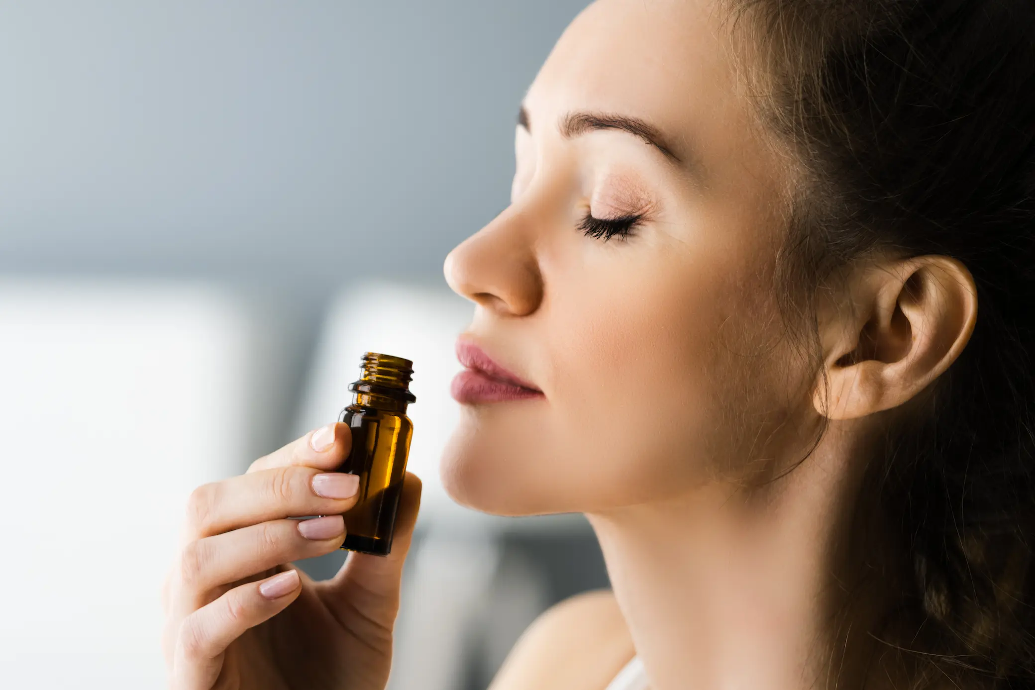 Femme et huile essentielle Femme sentant une huile essentielle, phyto-aromathérapie en médecine intégrative