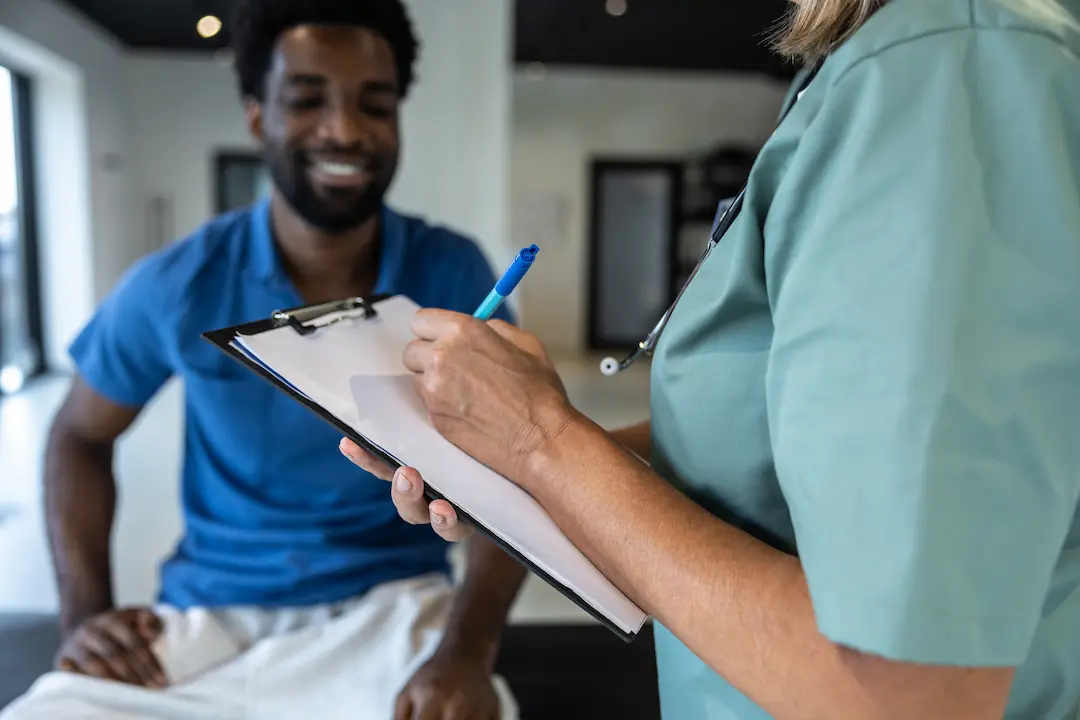 Médecin ostéopathe échangeant avec son patient avant la consultation